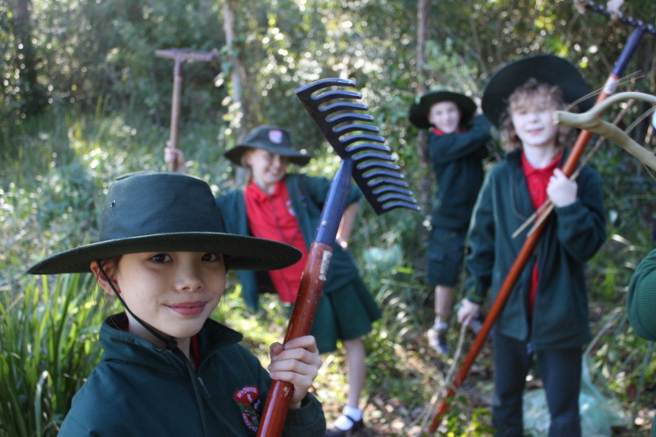 a student is posing for picture with a garden instruments